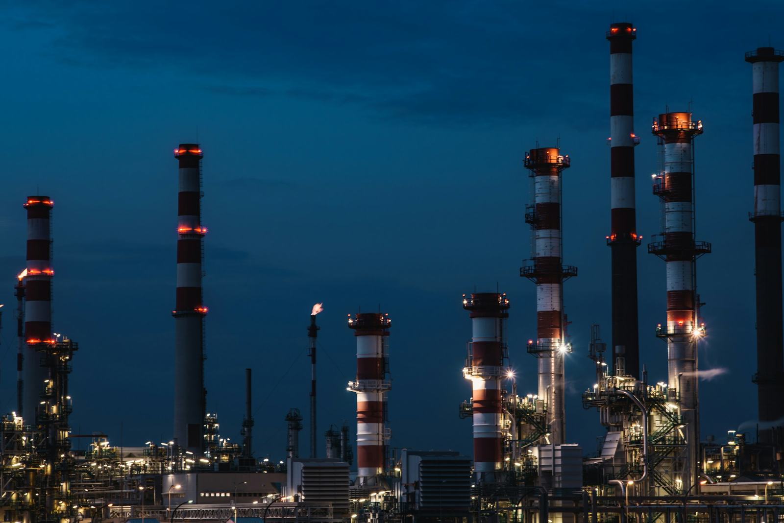 Illuminated industrial process plant with structural towers and pipework at dusk